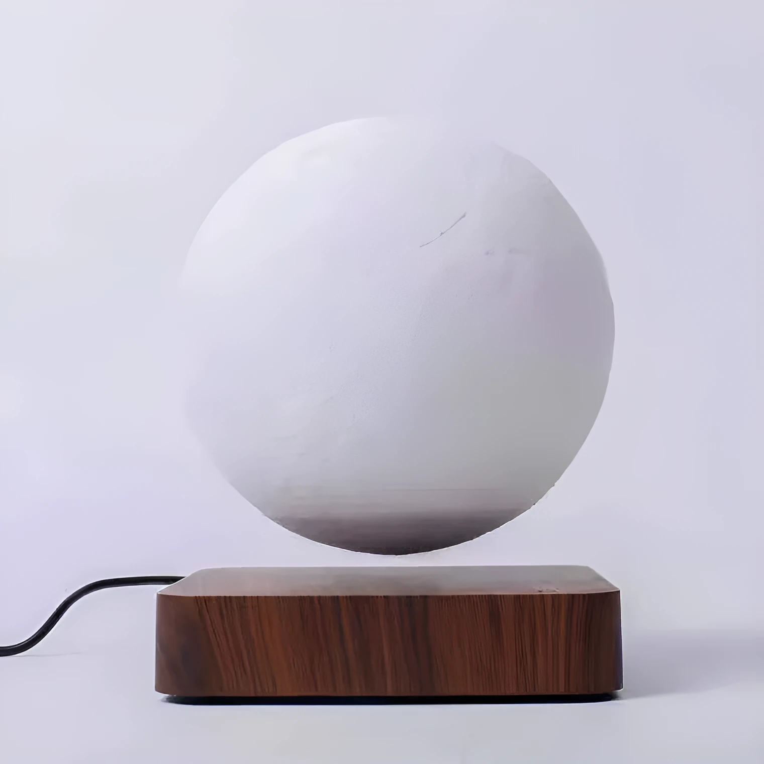 Magnetic levitation moon night light with 14cm 3D-printed planet suspended above a dark peach wood base