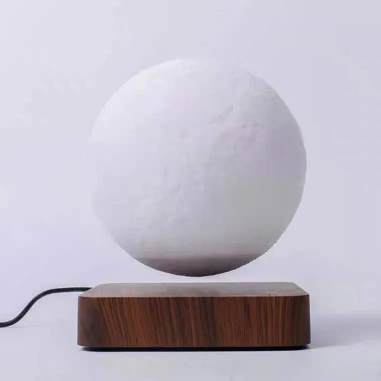 Magnetic levitation moon night light with 14cm 3D-printed planet suspended above a dark peach wood base