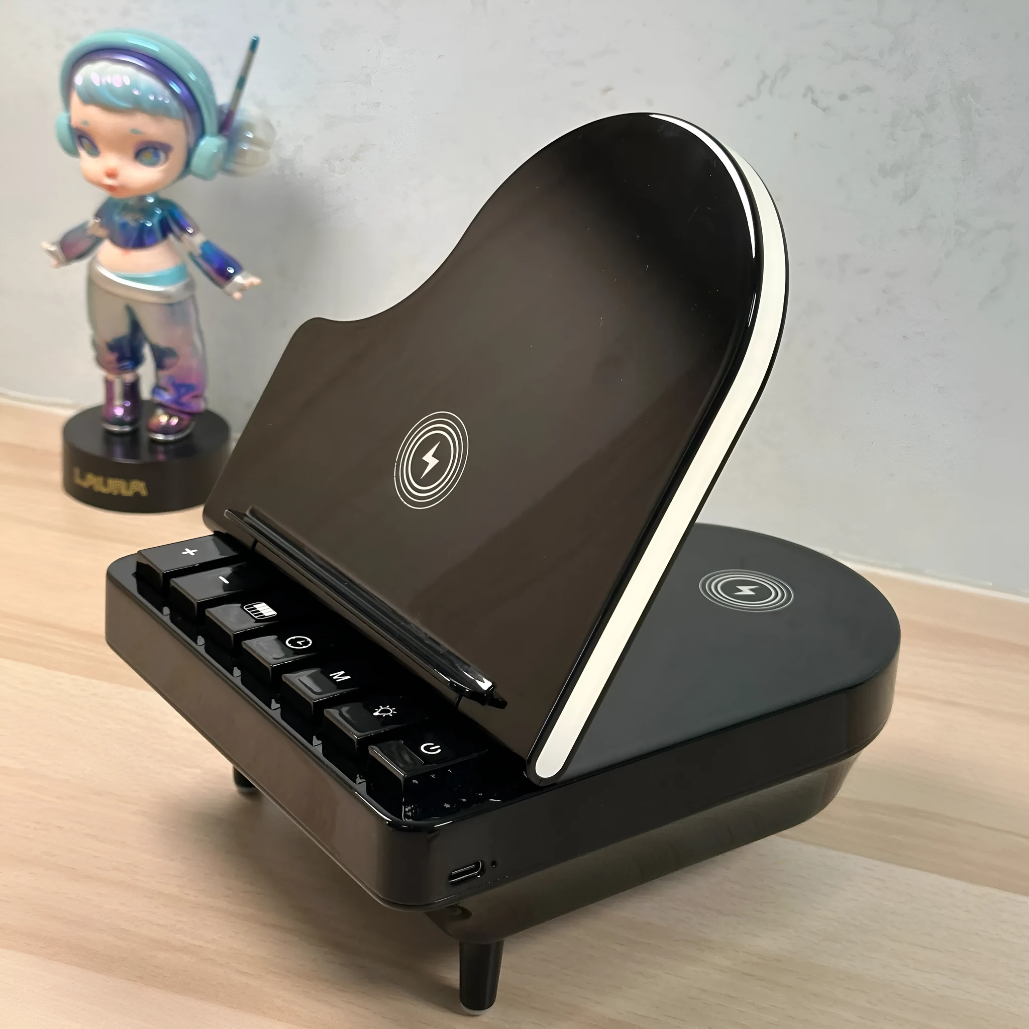 Black multi-function Bluetooth speaker wireless charger and phone holder on a desk