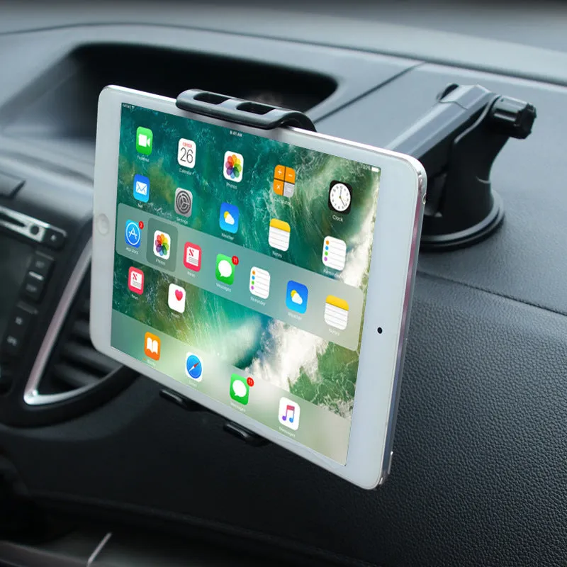 Black universal tablet PC car stand bracket clamped to dashboard centre console holding a tablet