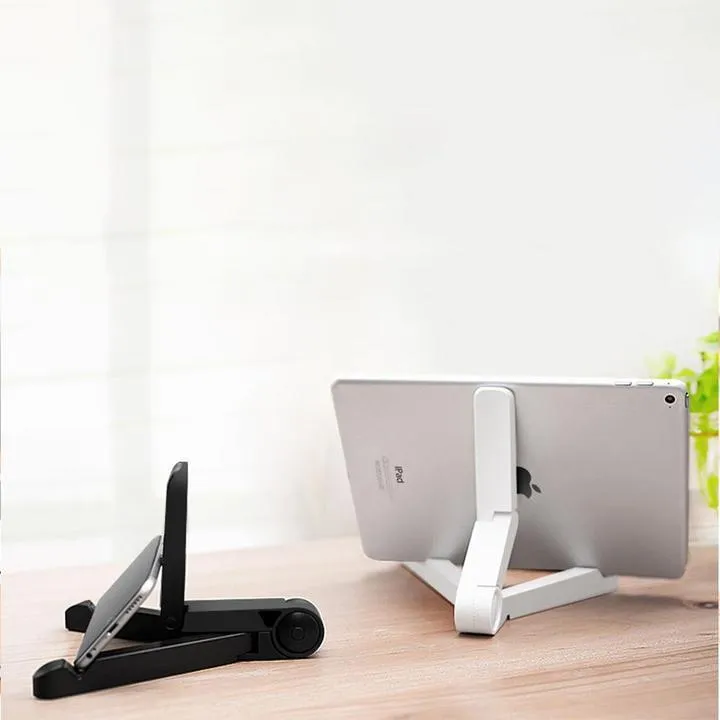 Black foldable tablet holder showing folded size next to tablet for scale