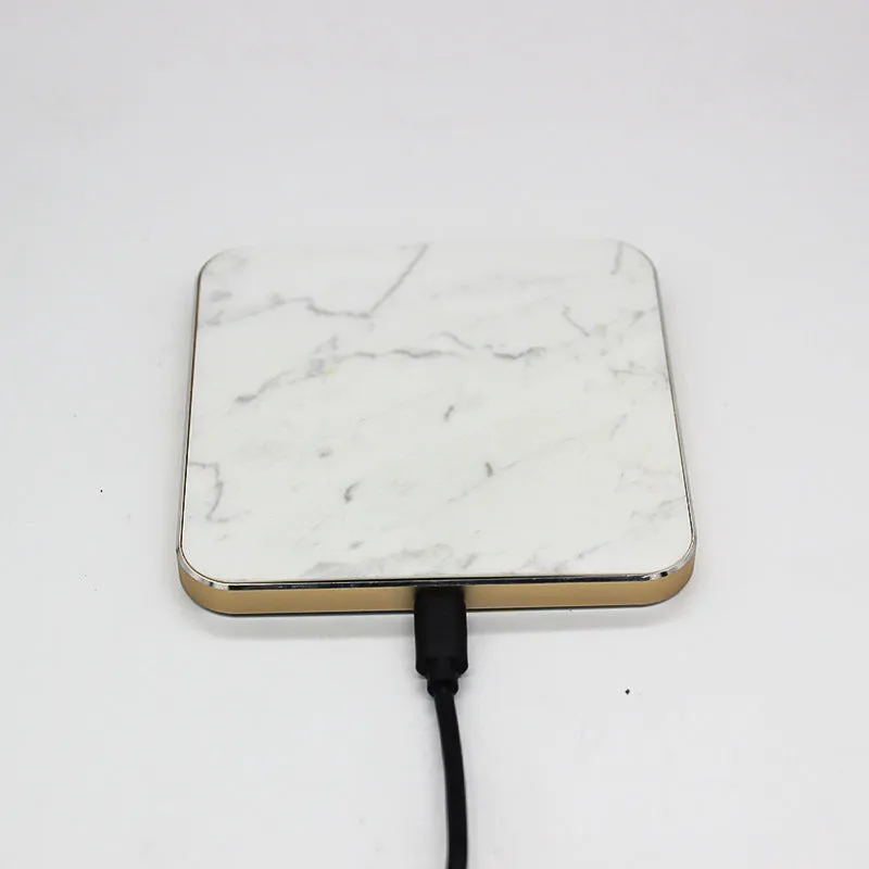 Real marble wireless charger on a desk with indicator light showing blue charging status