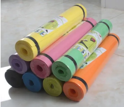 Red EVA fitness yoga mat rolled up next to its storage bag, showing textured surface.