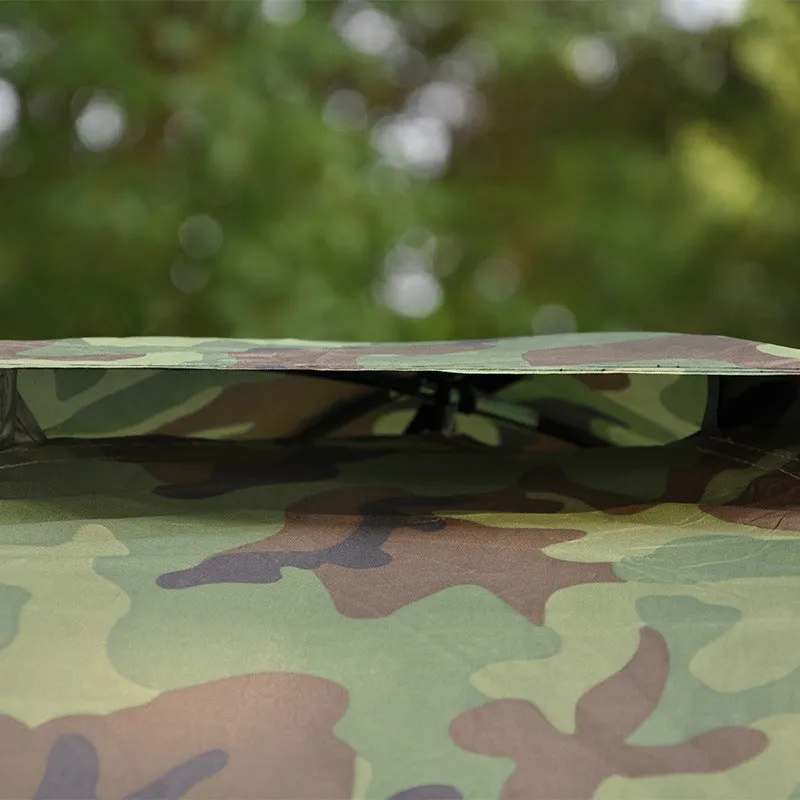 Green camouflage two-person camping tent with triangular skylight and fibre glass poles pitched outdoors.