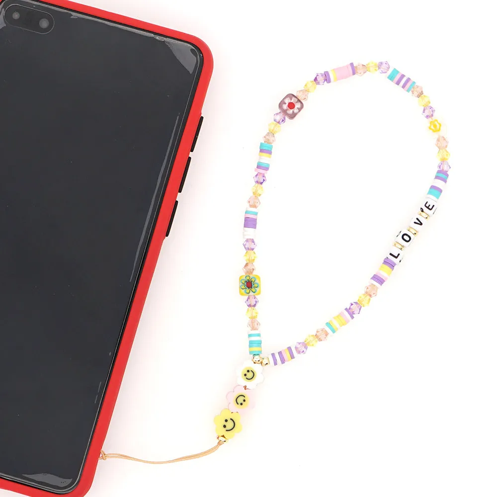 Handmade bohemian smiley soft ceramic beaded phone chain with crystal and acrylic letter beads on a light background