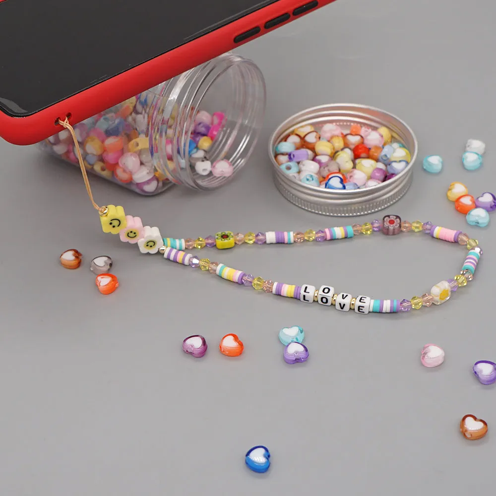 Handmade bohemian smiley soft ceramic beaded phone chain with crystal and acrylic letter beads on a light background