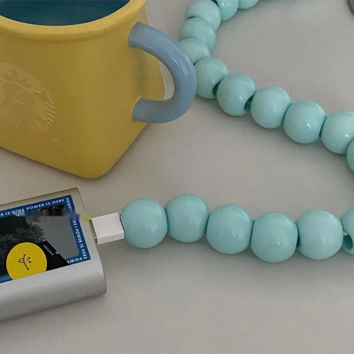 Mint green USB data cable with straight head connector on a white background