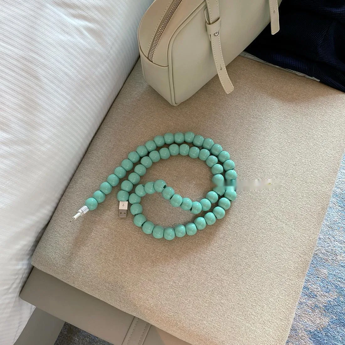 Mint green USB data cable with straight head connector on a white background