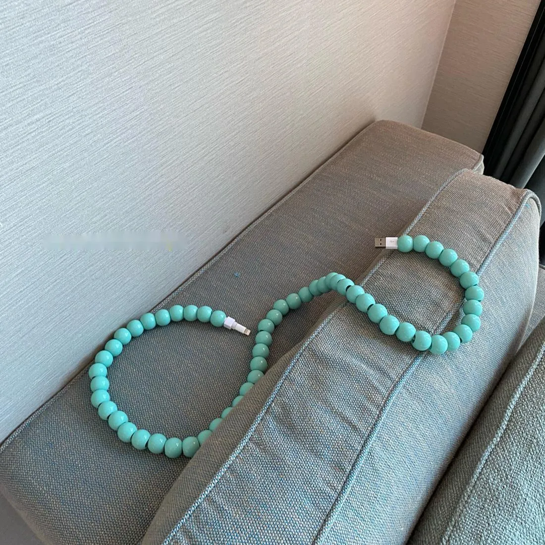 Mint green USB data cable with straight head connector on a white background