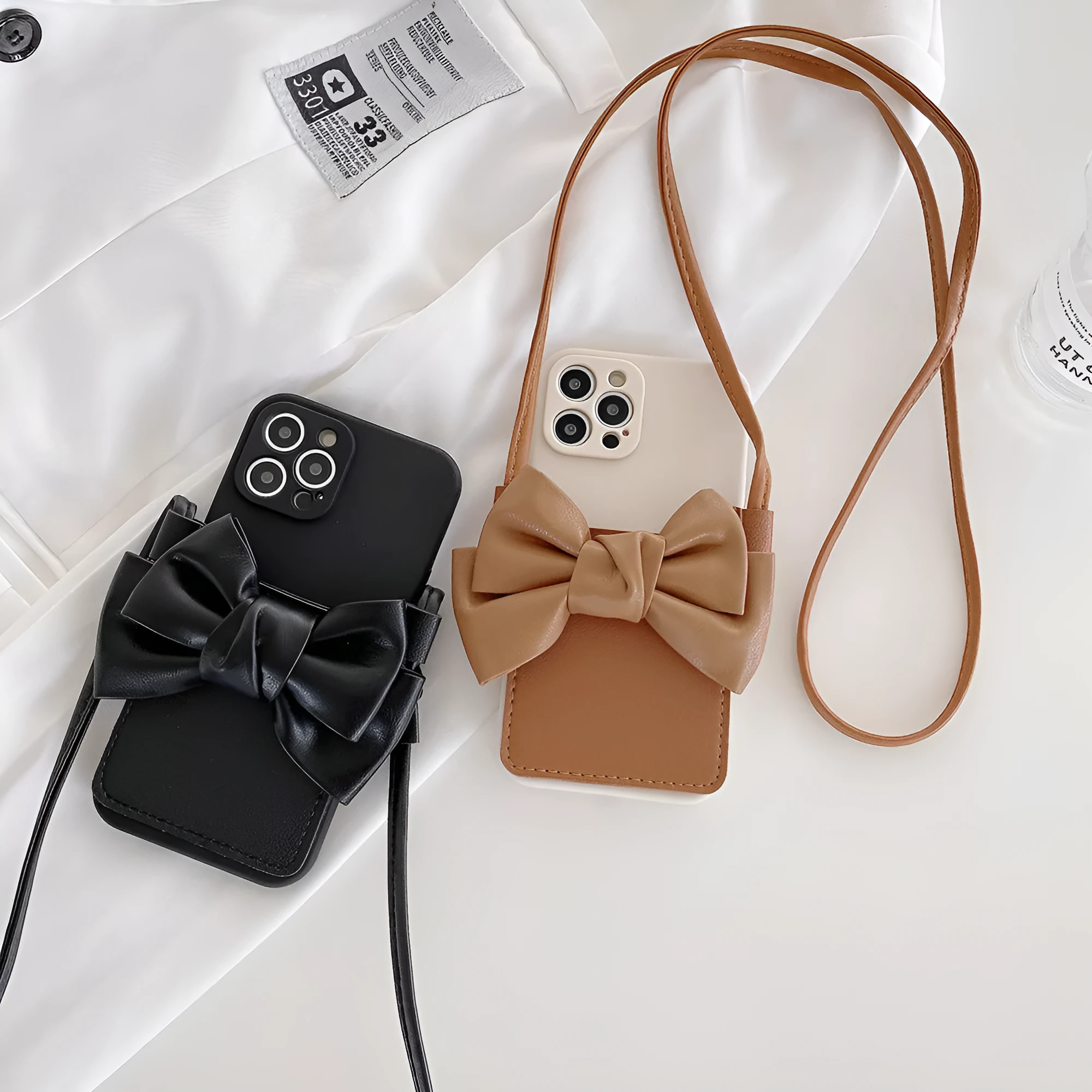 Ladies crossbody bag phone case in black with bow and strap showing iPhone in case front view