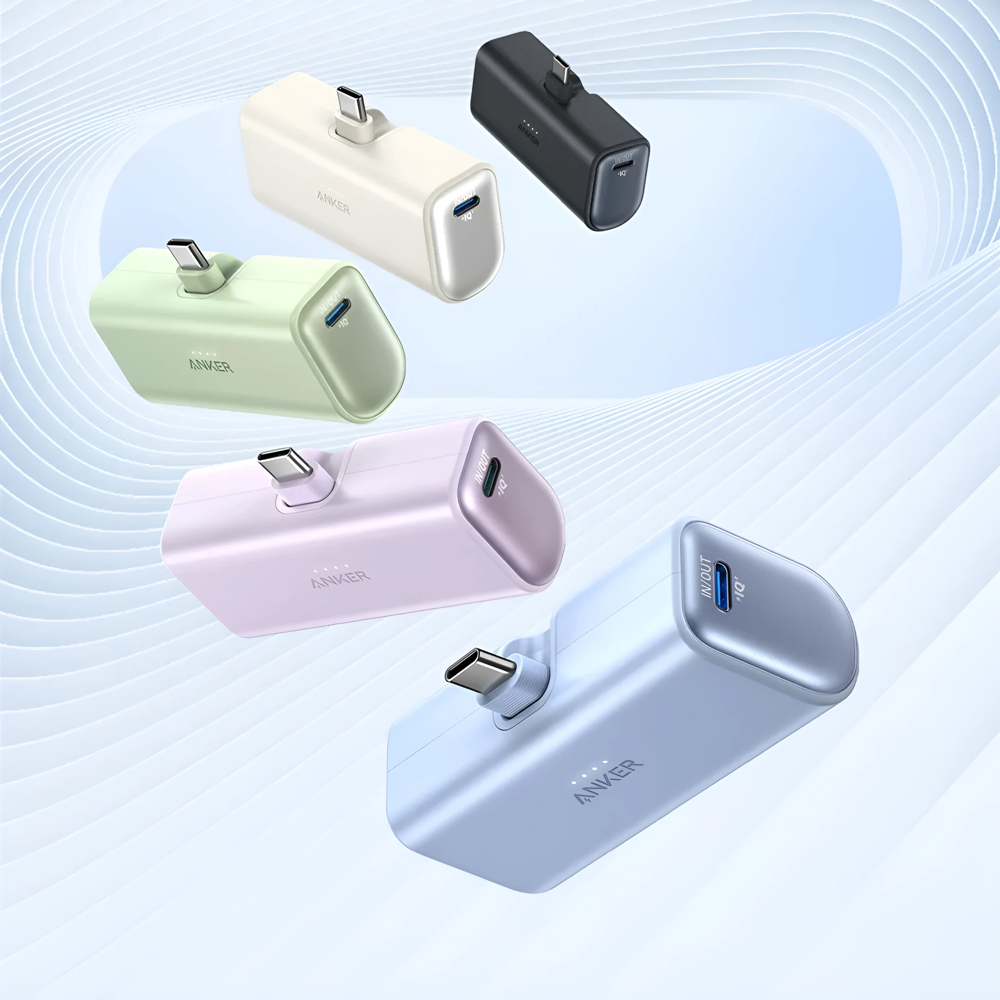 Small capsule-shaped power bank in multiple colours showing built-in foldable USB-C cable and compact size.
