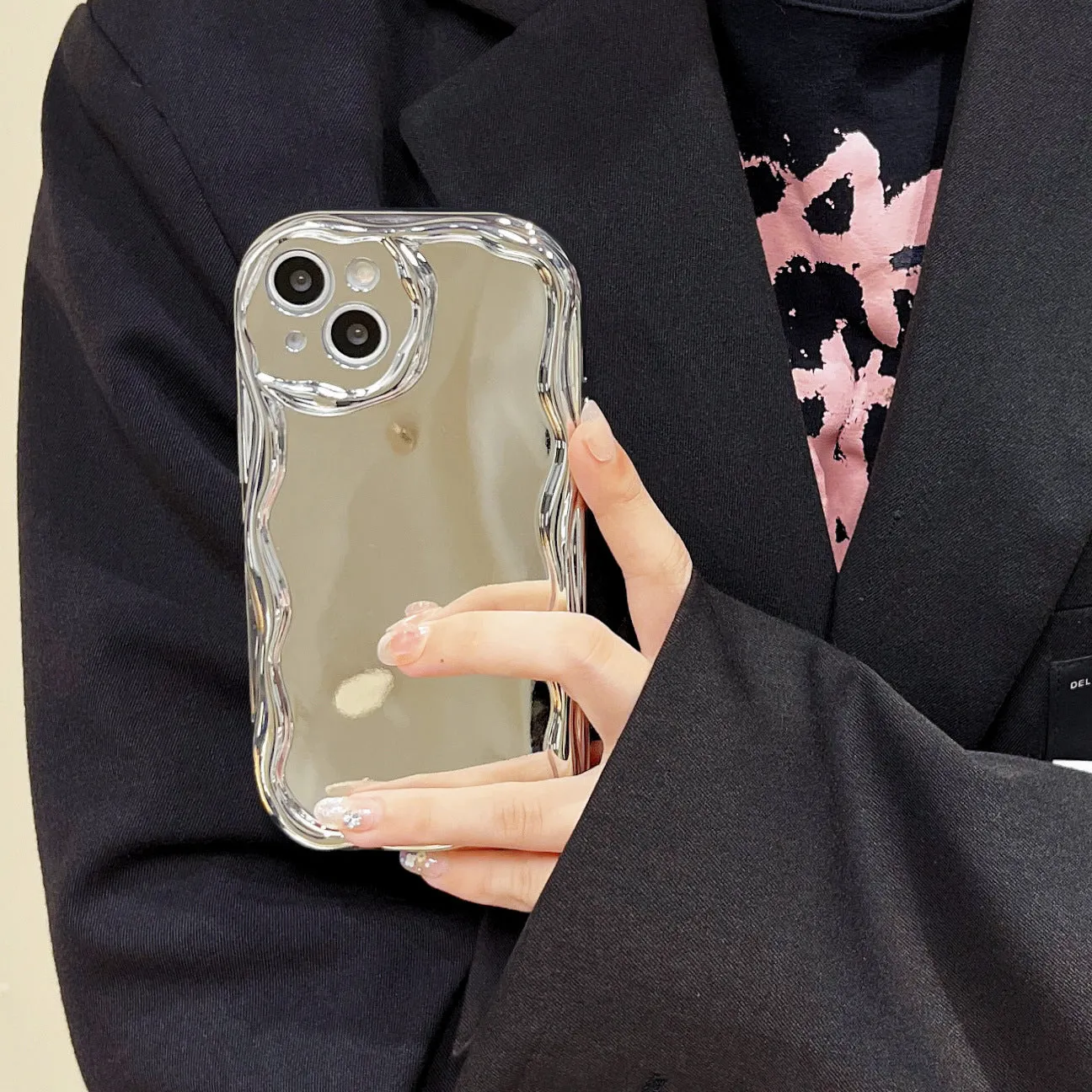 Silver electroplated cream grain silicone phone case with bracelet on a white background
