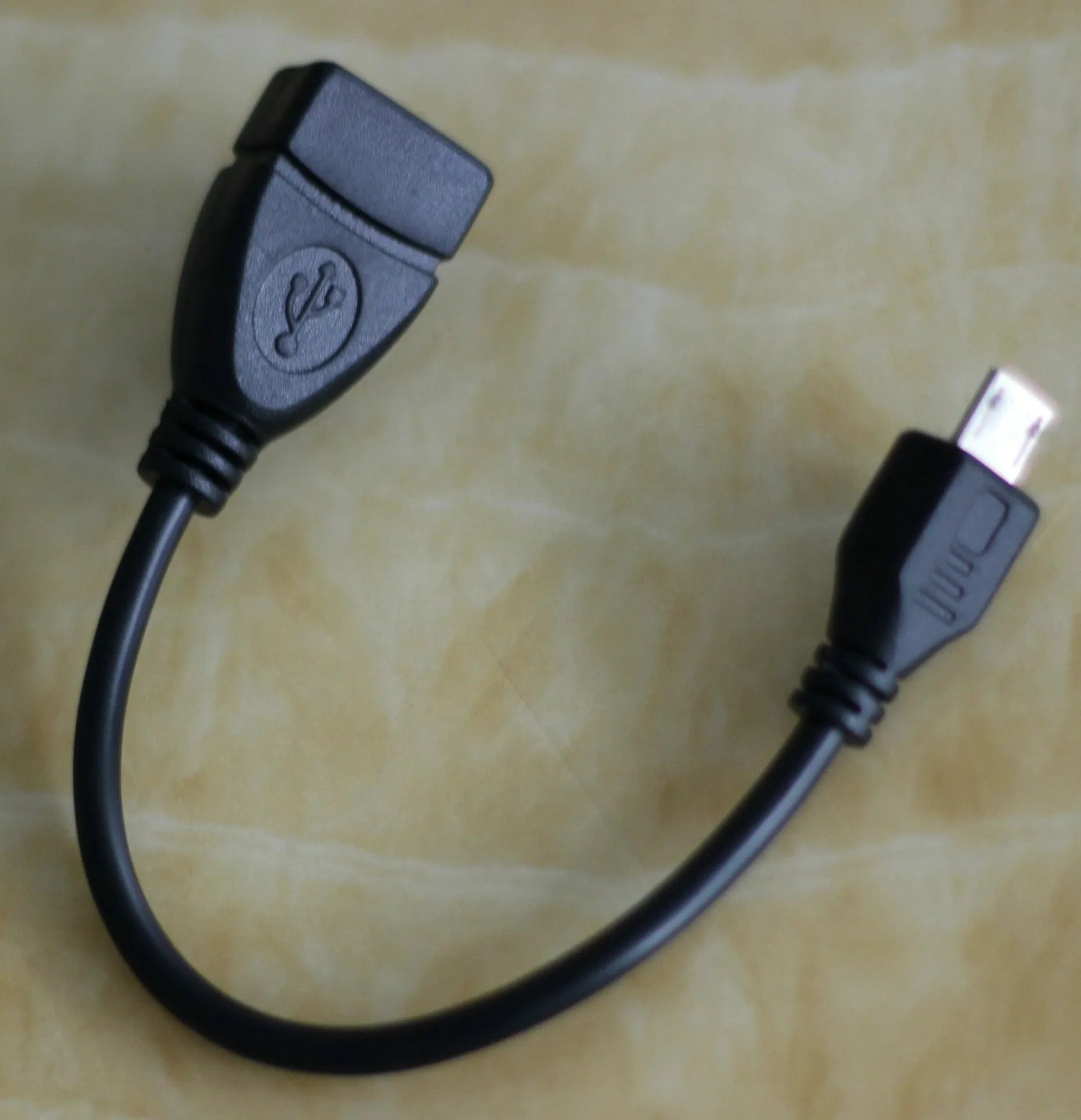 Black USB OTG cable with Mini USB and TYPE-C connectors on white background