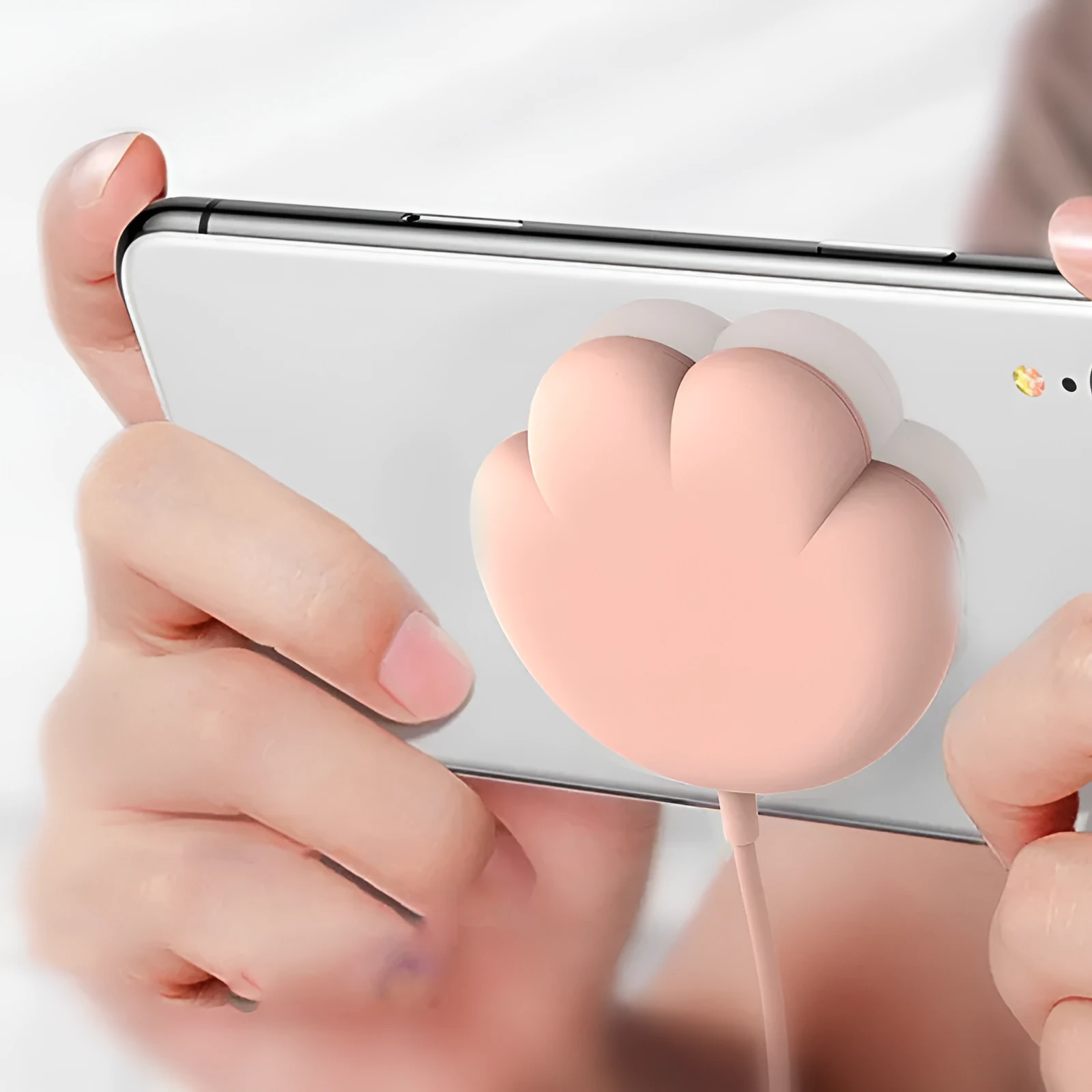 Pink cat claw sucker wireless charger with USB cable on a desk