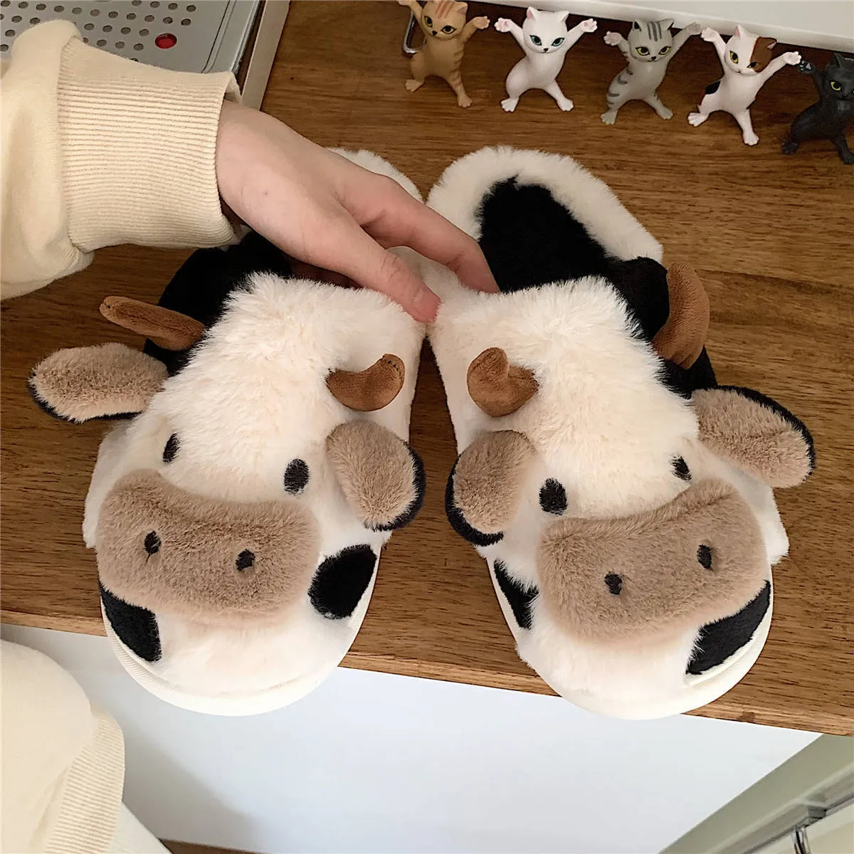 White and coffee cartoon cow slippers for women with plush faux fur and a textured non-slip sole.
