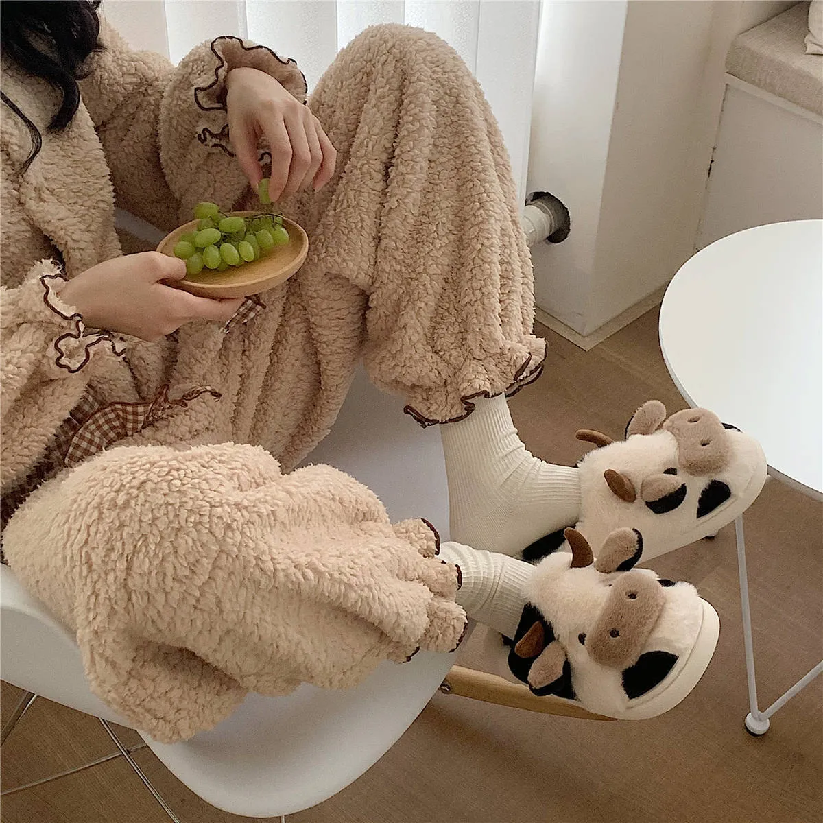 White and coffee cartoon cow slippers for women with plush faux fur and a textured non-slip sole.