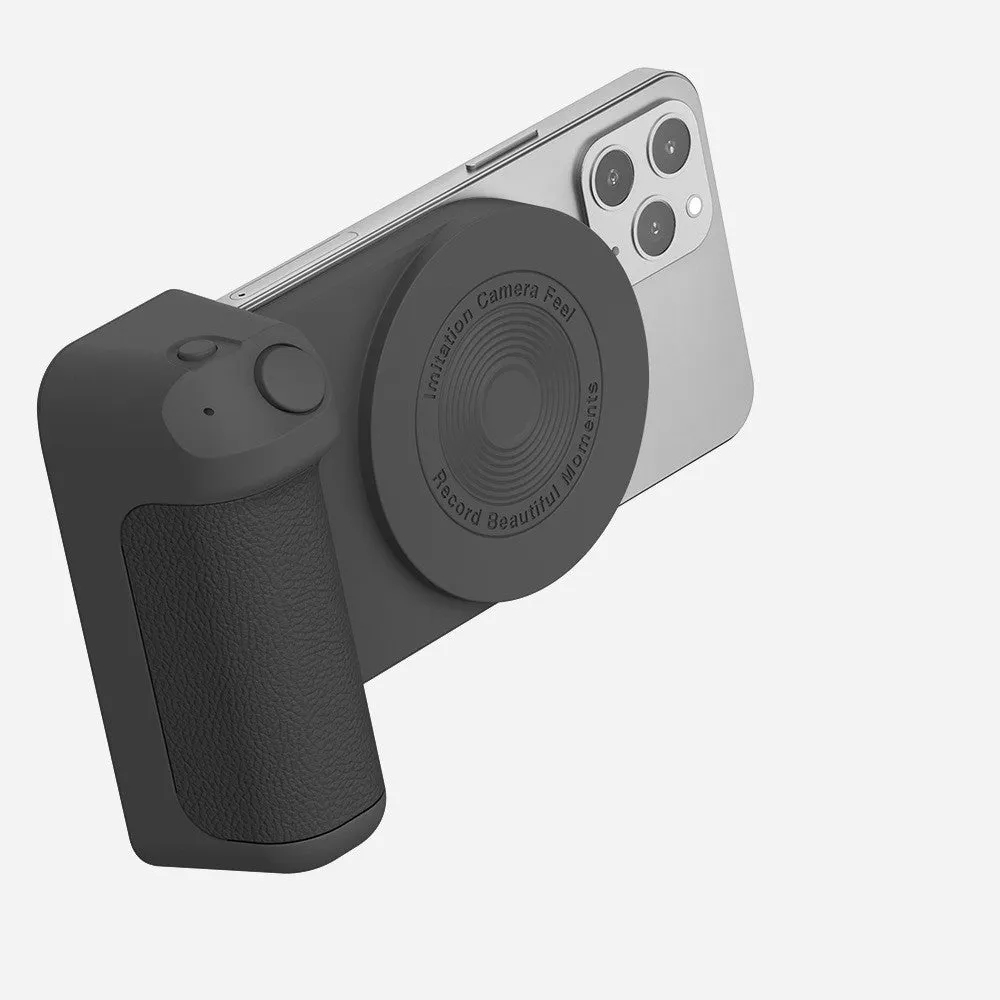 Black magnetic phone camera grip with rotatable stand and ergonomic PU leather handle on a table.