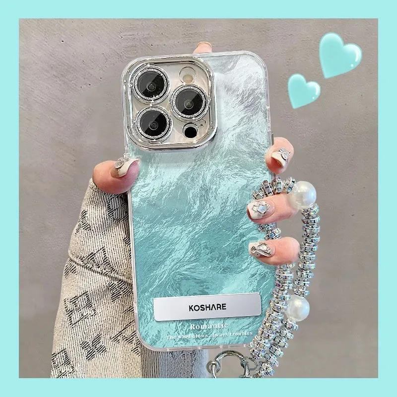 Ice blue gradient hard PC phone case with invisible bracket and silver chain for iPhone set on a white surface