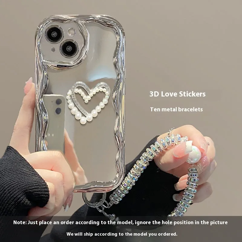 Silver grey silicone phone case for iPhone 15 Pro Max with three-dimensional pearls and chain, electroplated finish, and matching bracelet on a table