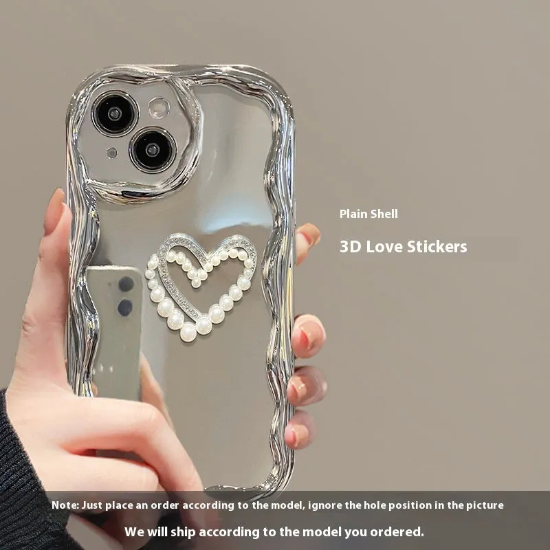 Silver grey silicone phone case for iPhone 15 Pro Max with three-dimensional pearls and chain, electroplated finish, and matching bracelet on a table