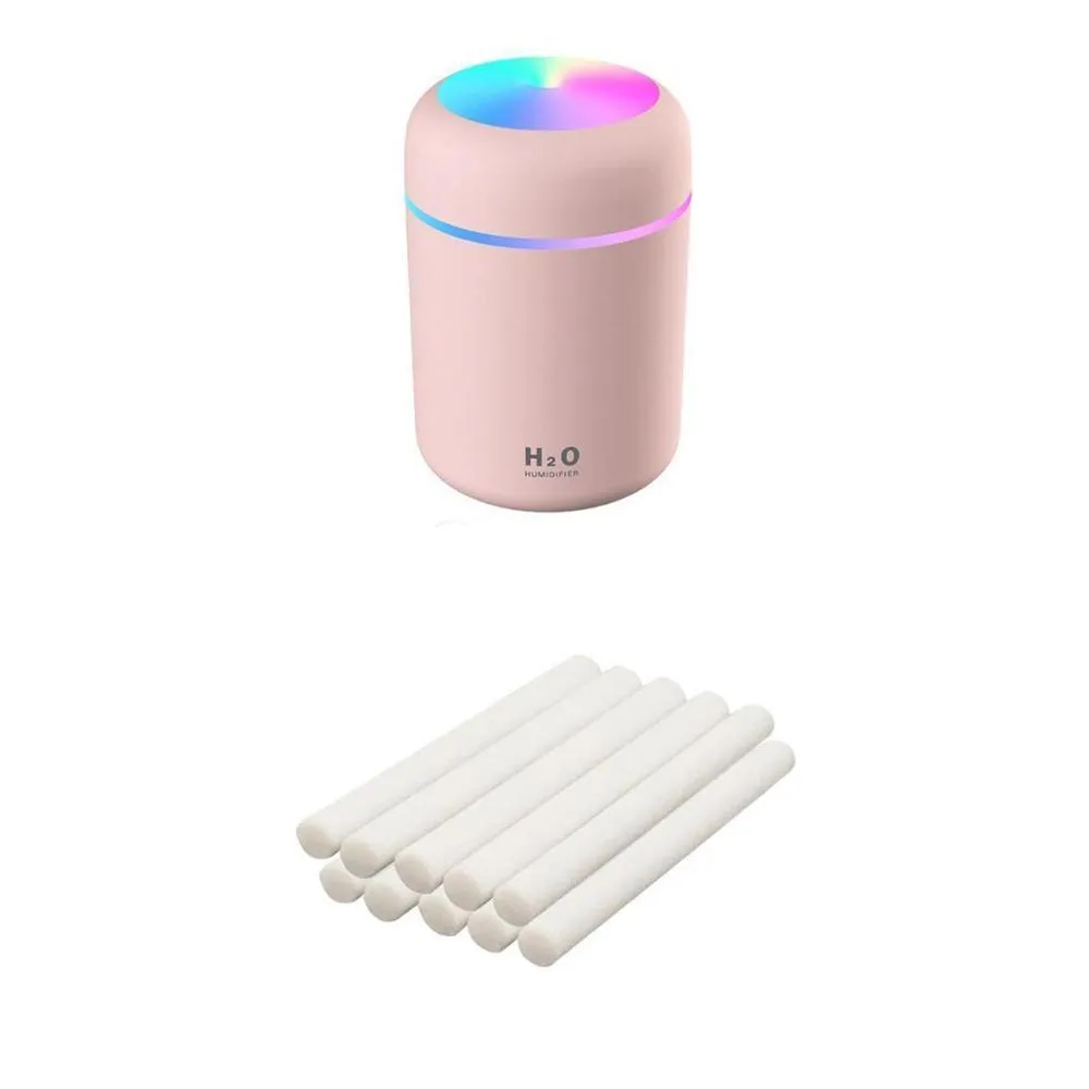 Pink USB desktop humidifier with coloured LED lights and water tank on a wooden desk.