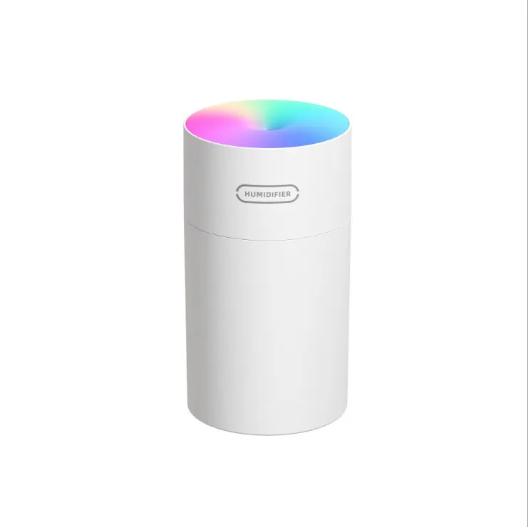 Pink USB desktop humidifier with coloured LED lights and water tank on a wooden desk.