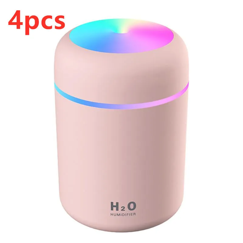Pink USB desktop humidifier with coloured LED lights and water tank on a wooden desk.