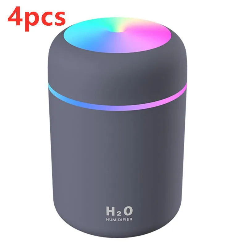 Pink USB desktop humidifier with coloured LED lights and water tank on a wooden desk.