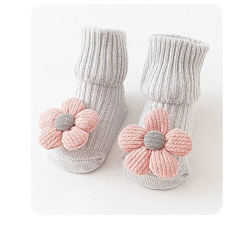 Cotton baby floor socks in various colours and patterns including pink bows, grey stars, and panda design.