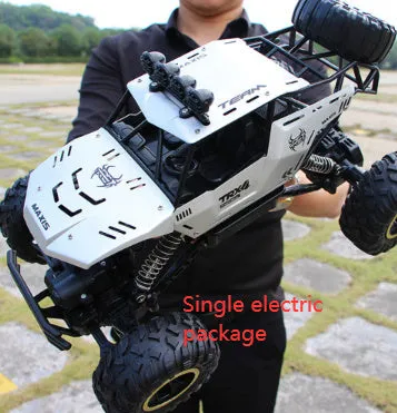 Black and silver remote control off-road car on rough terrain showing four-wheel drive and climbing capability.