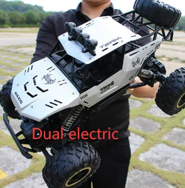 Black and silver remote control off-road car on rough terrain showing four-wheel drive and climbing capability.