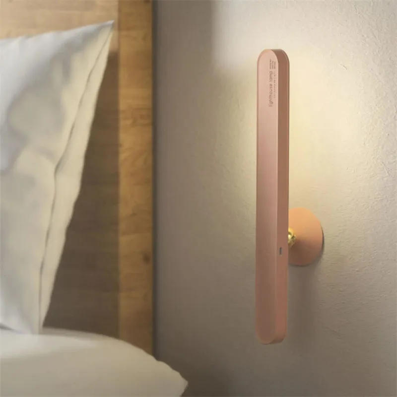 White geometric desk lamp with magnetic base mounted on a metal wall surface.