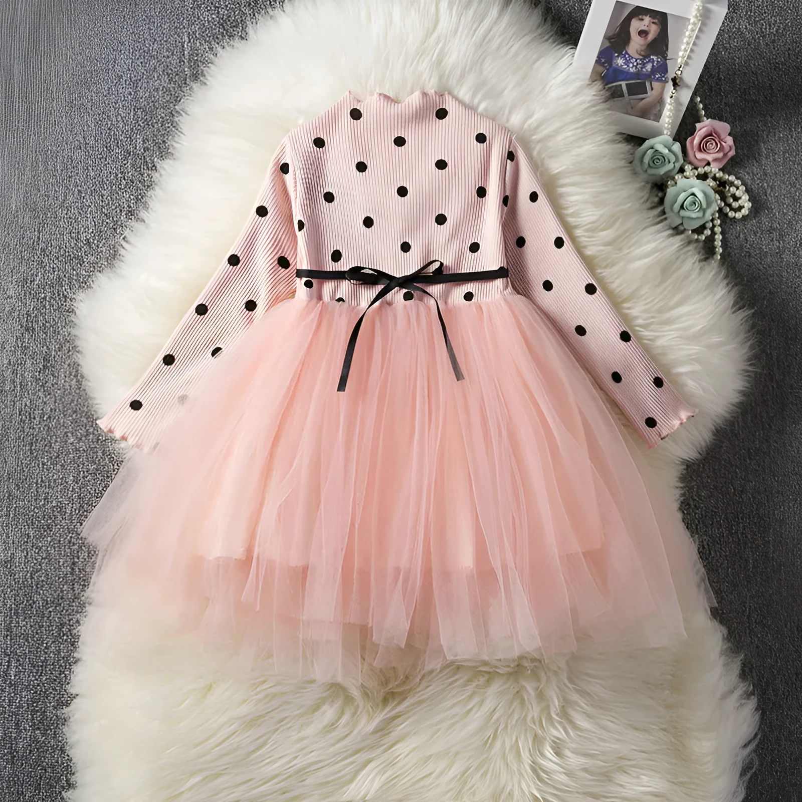 Baby girl wearing a long sleeve black tutu lace dress for a first birthday party.