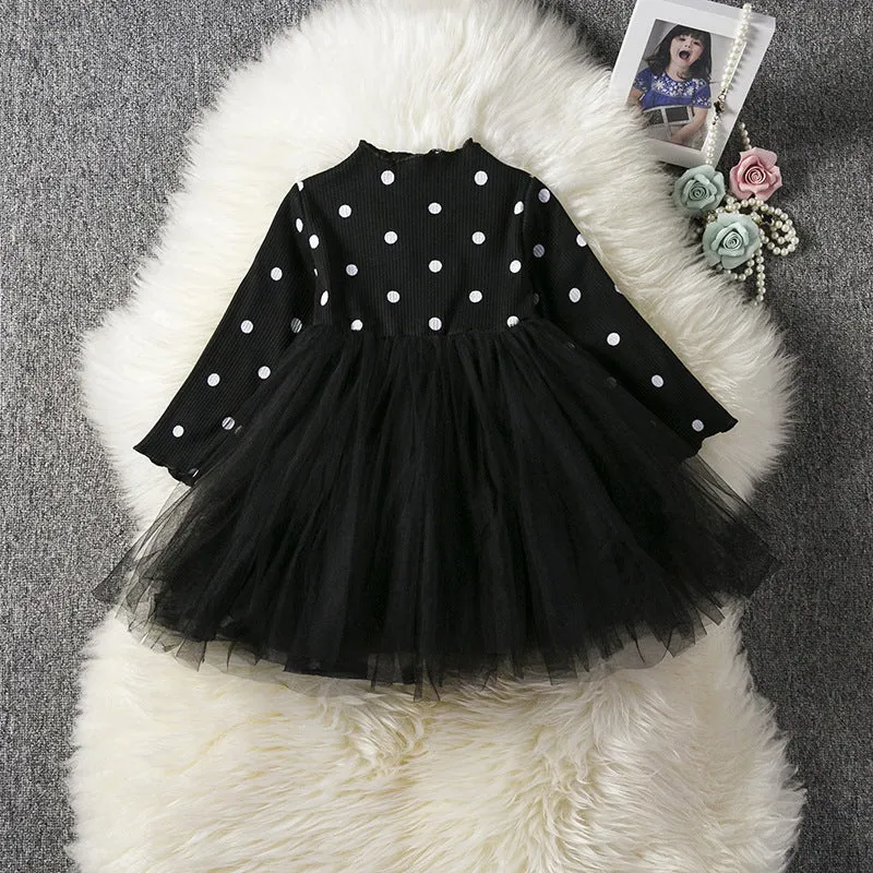 Baby girl wearing a long sleeve black tutu lace dress for a first birthday party.