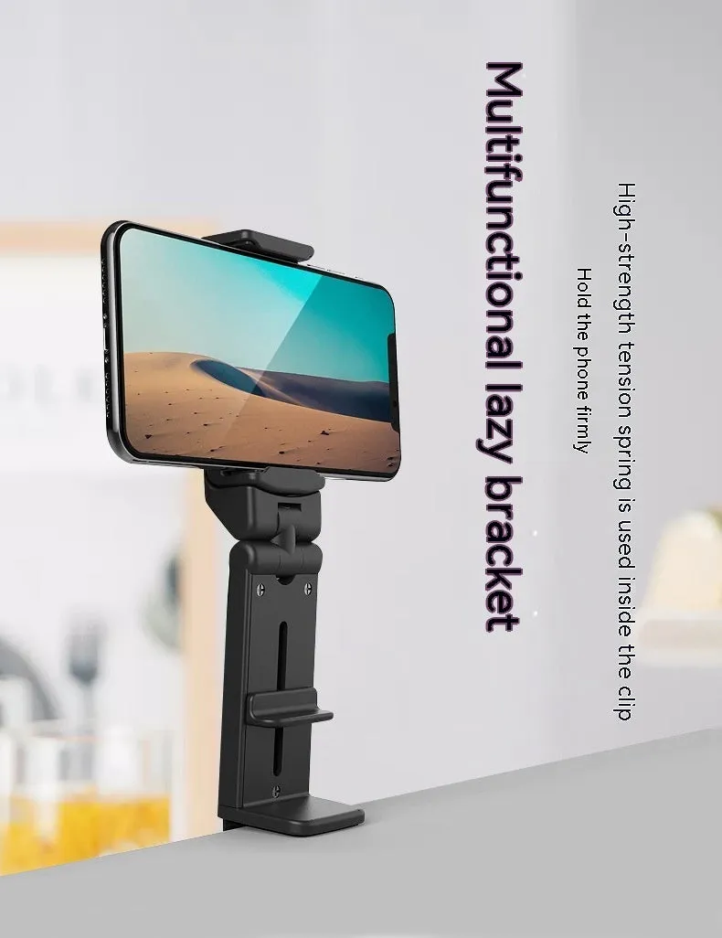 Black foldable ABS phone holder with 360-degree rotation on a desk next to a smartphone