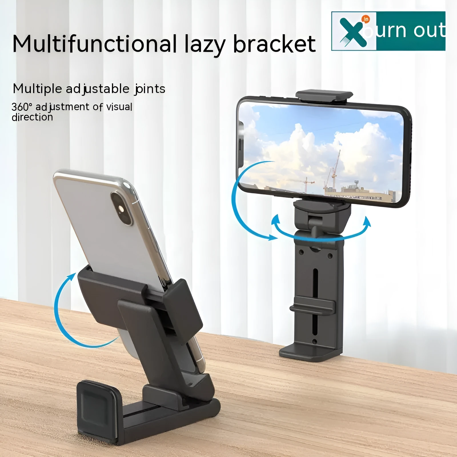 Black foldable ABS phone holder with 360-degree rotation on a desk next to a smartphone