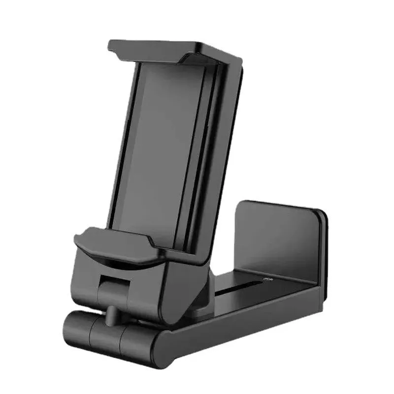 Black foldable ABS phone holder with 360-degree rotation on a desk next to a smartphone