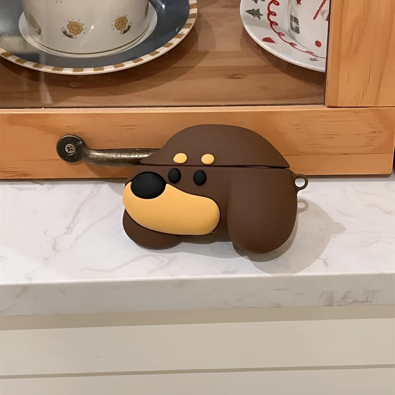 Brown puppy silicone earphone case on AirPods charging case with embossed cartoon design
