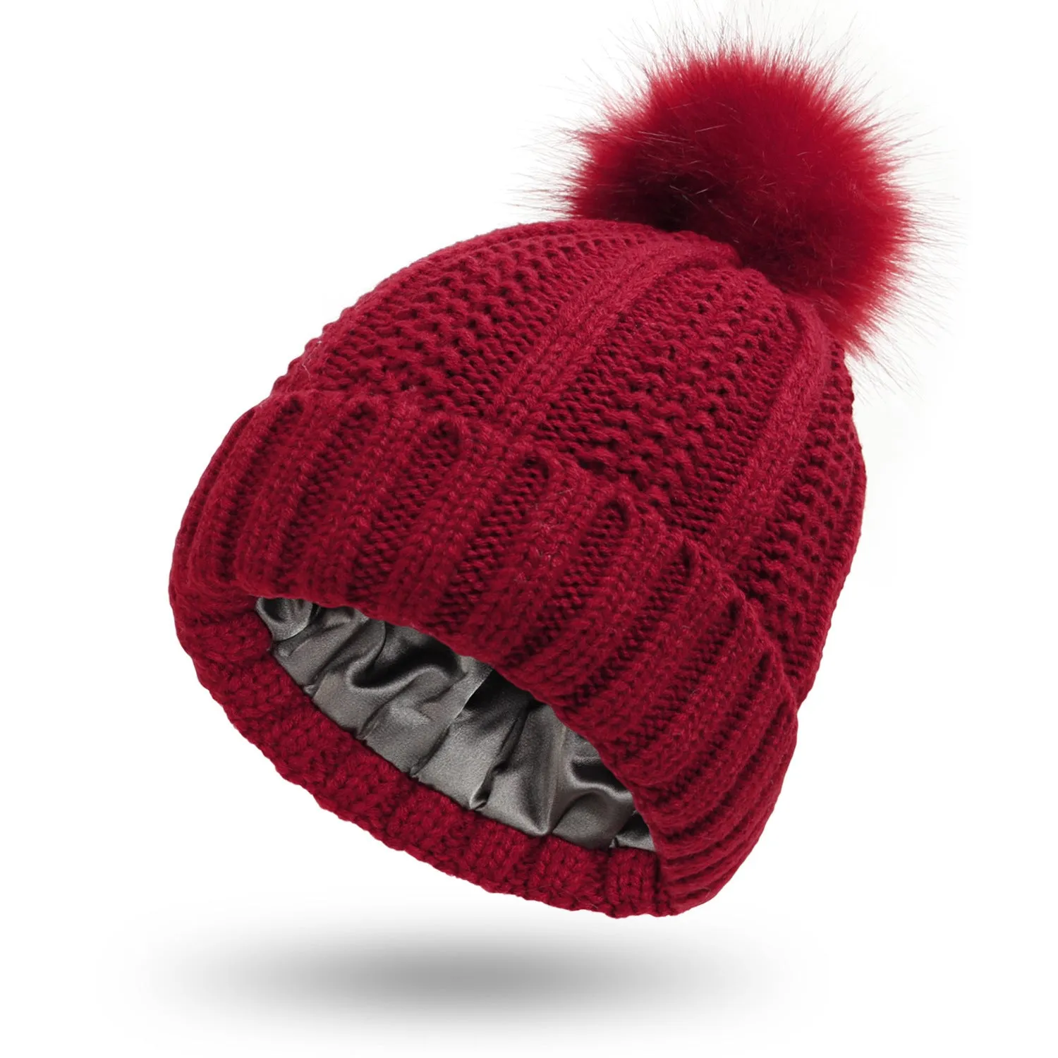 Women's knitted beanie hat with faux fur pom pom and satin lining in multiple colour options.