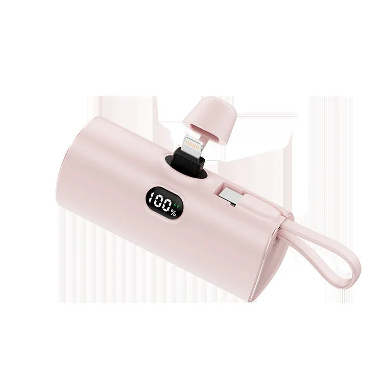 Compact black power bank with digital display and a folding AC plug extended, showing its pocket-sized dimensions.