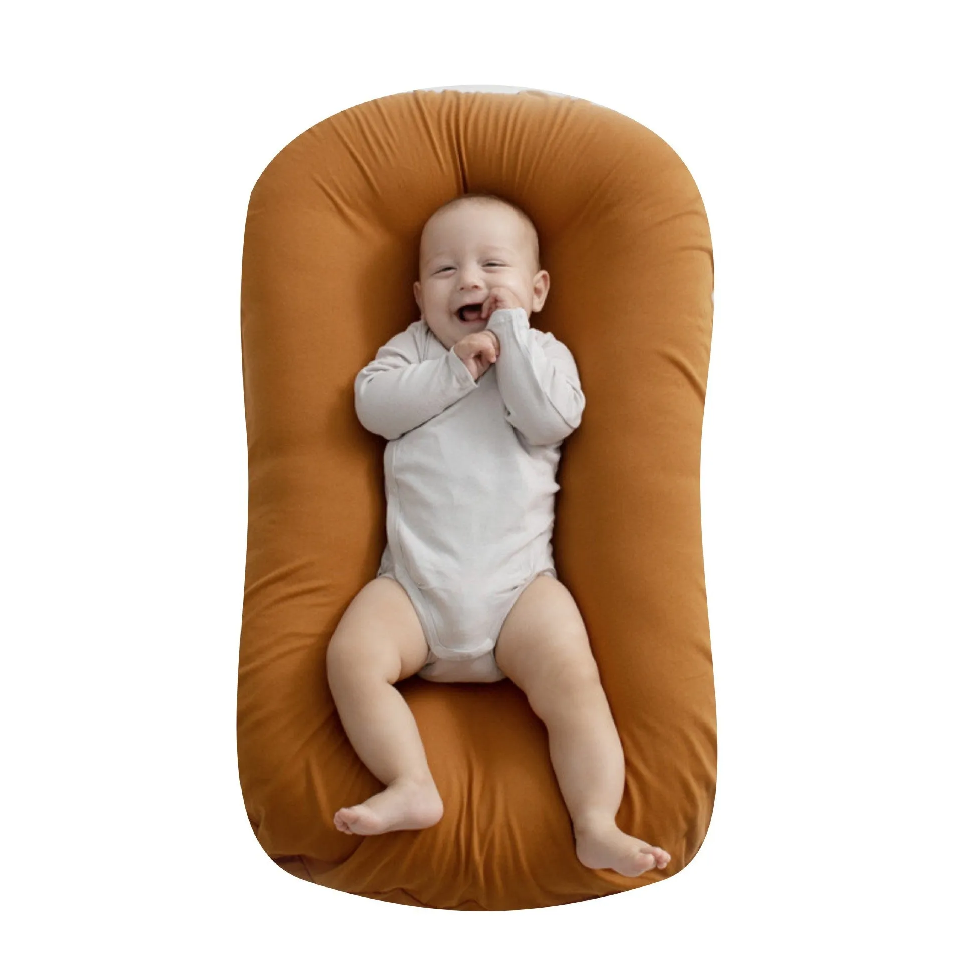 Cotton portable baby nest crib for newborns, beige colour, shown on a bed.