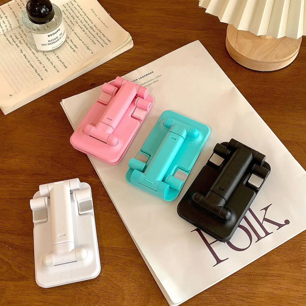 Folding plastic mobile phone stand in pearl white on a flat surface