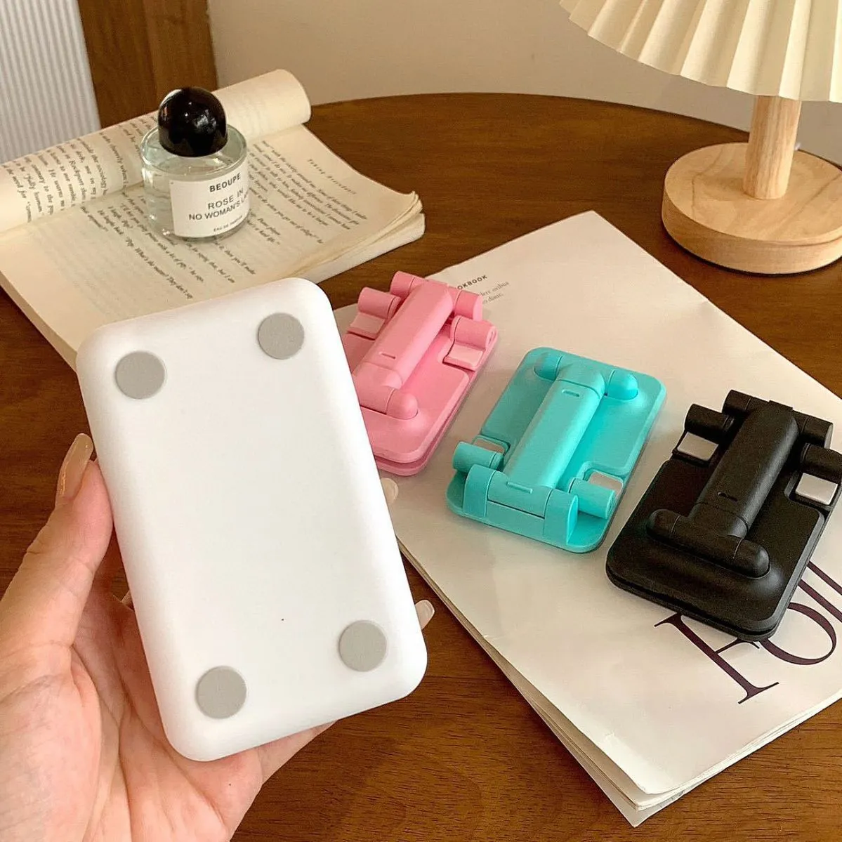 Folding plastic mobile phone stand in pearl white on a flat surface