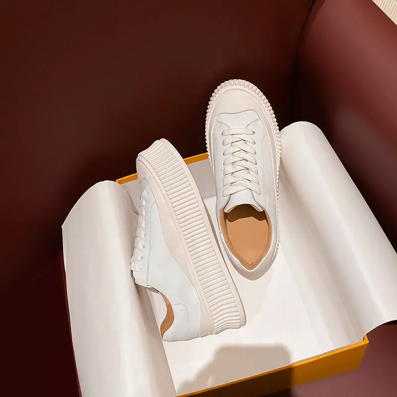 Women's white suede mid-top trainers with thick sole, back lacing, and cross binding detail on the heel.
