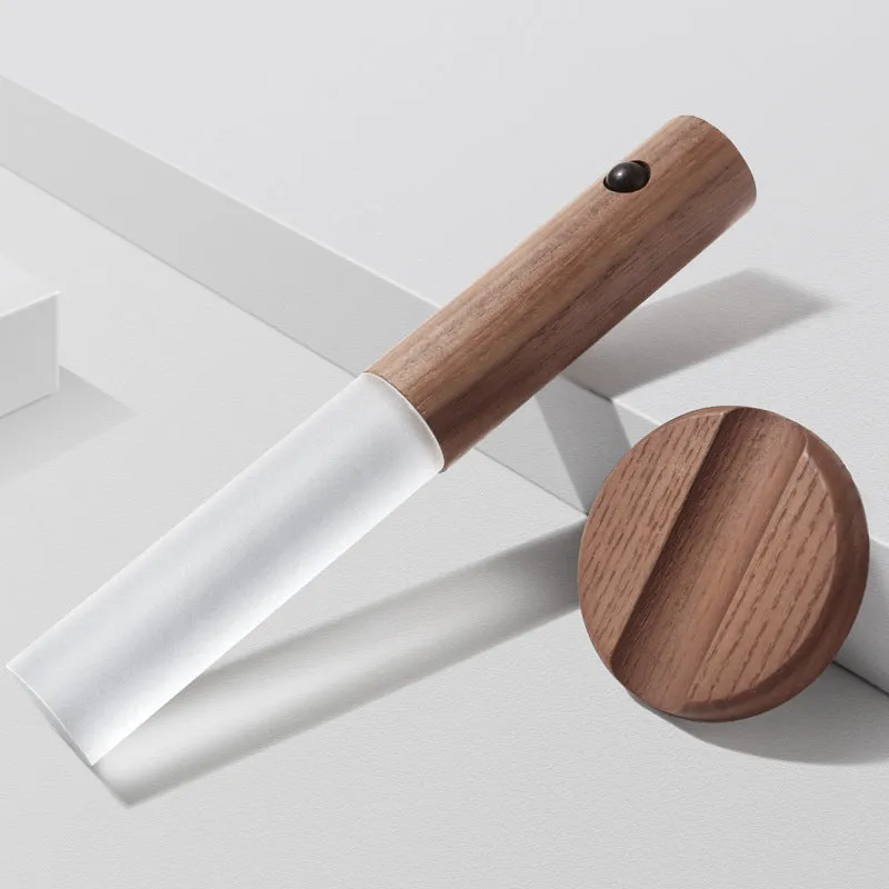 Smart sensor LED desk lamp in solid wood and acrylic, showing compact design beside a charging cable.