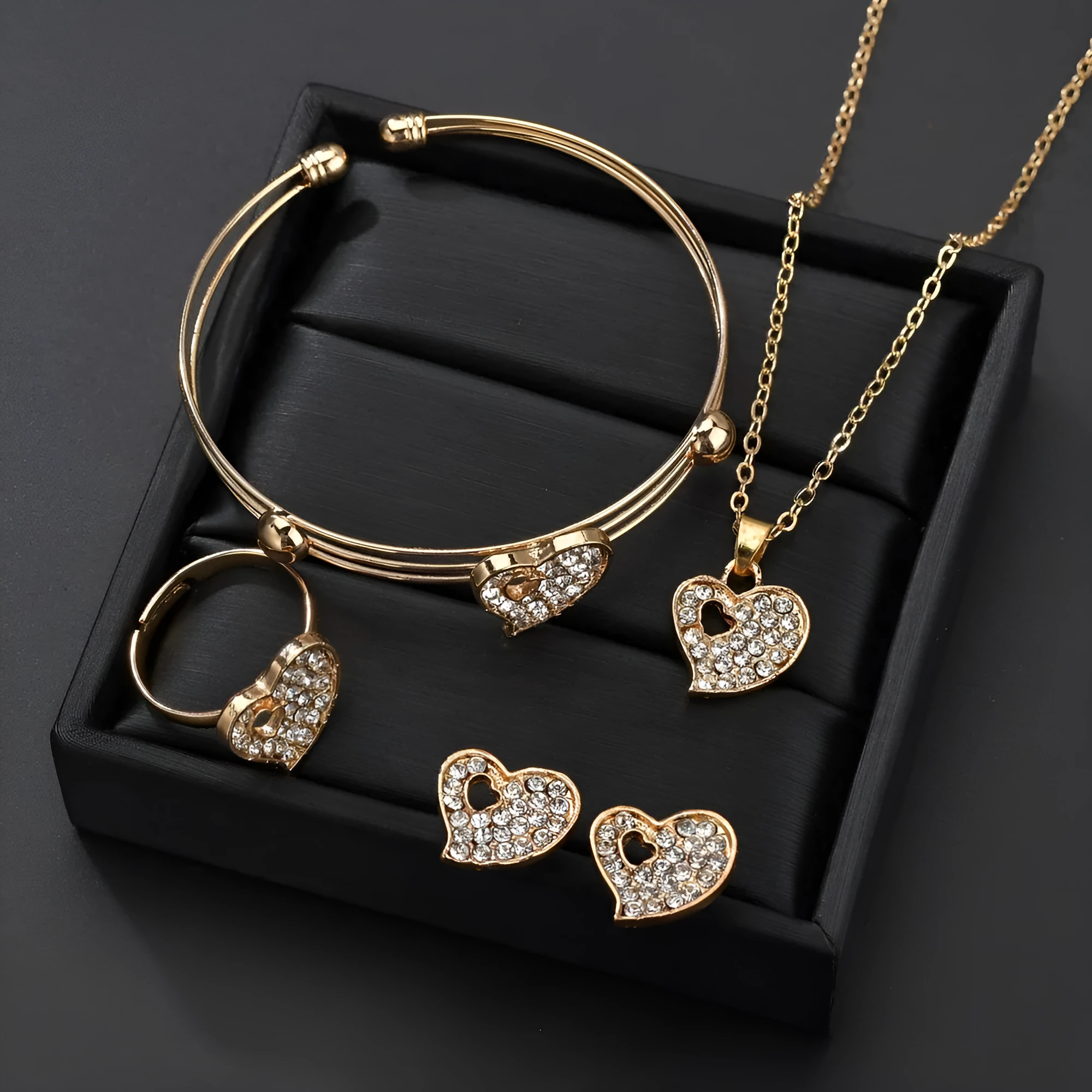 Gold tone alloy jewellery set with earrings, pendant and bracelet featuring love, water drop or bell patterns