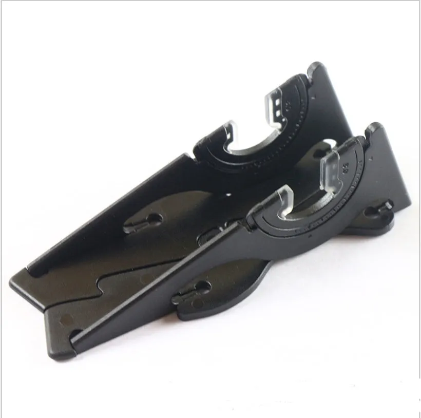 A black plastic card-type mobile phone stand on a desk.