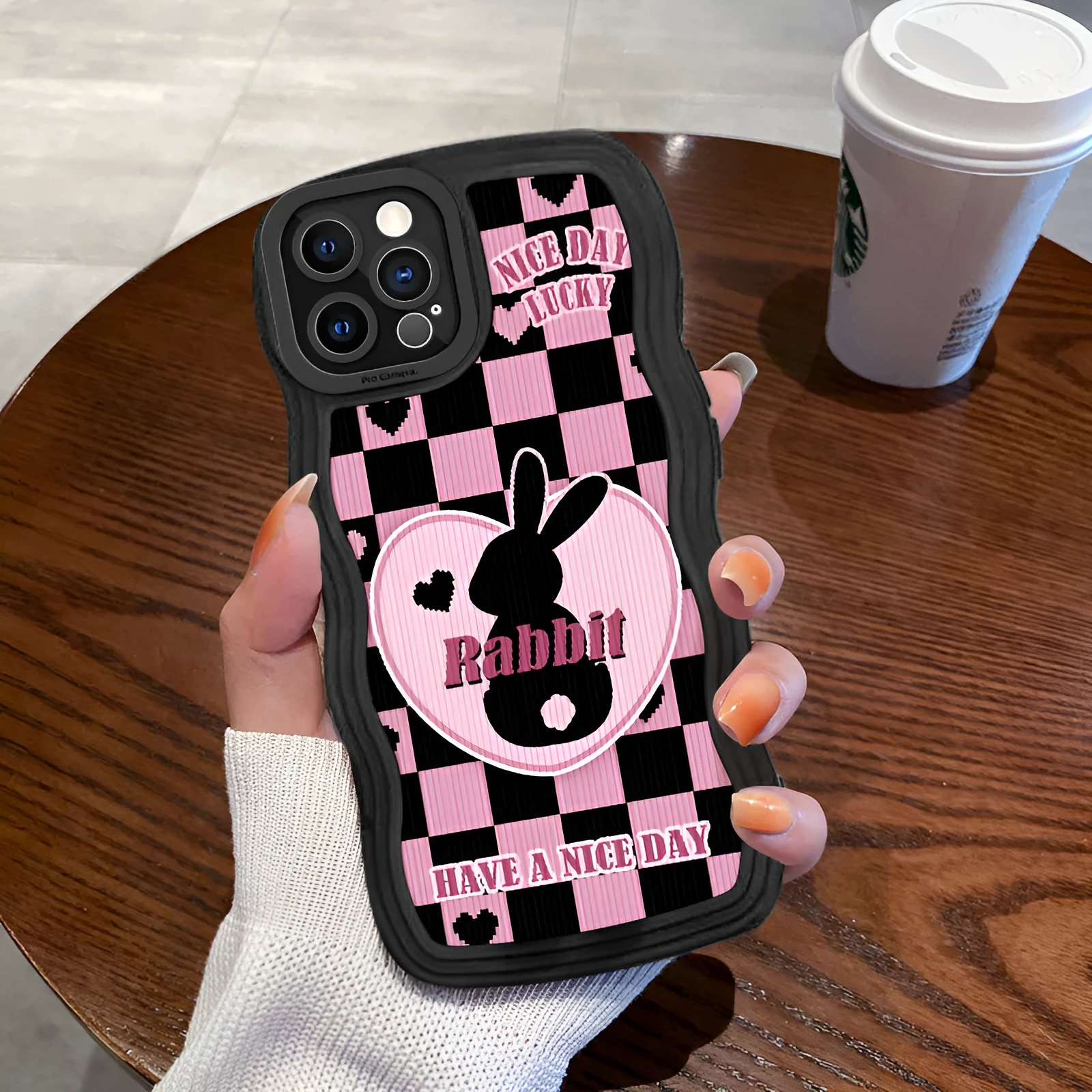 Cartoon creative TPU phone case with checkerboard bunny design on an iPhone 14, in wave black colour