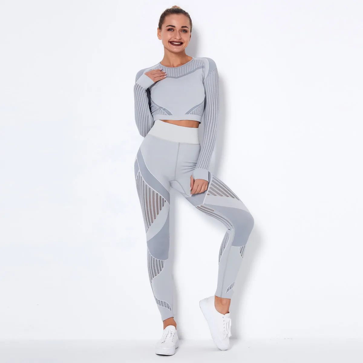 Woman wearing a seamless long-sleeved yoga suit in a neutral colour, demonstrating a stretch pose.