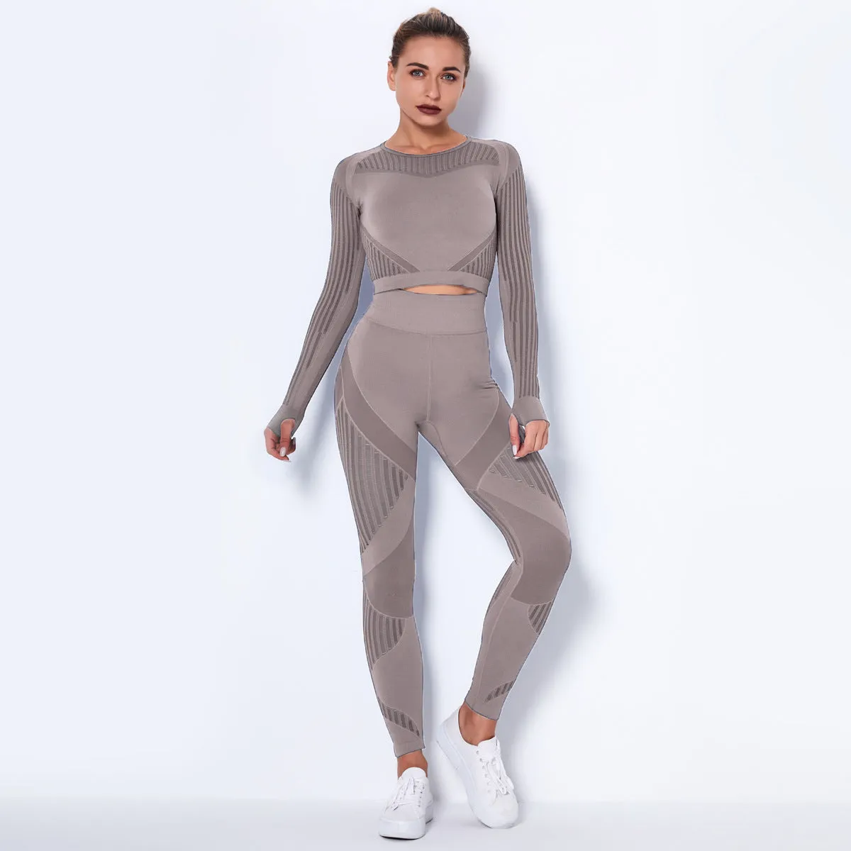 Woman wearing a seamless long-sleeved yoga suit in a neutral colour, demonstrating a stretch pose.